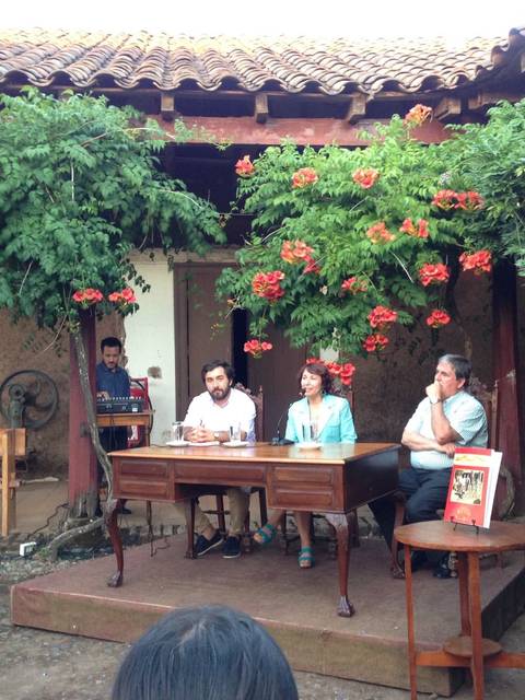 Un panel de discusión en un jardín con flores y un ambiente acogedor.