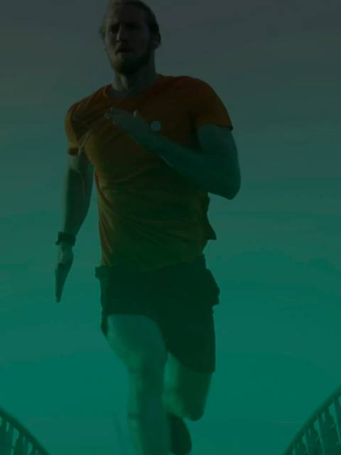 Un corredor está entrenando en un puente mientras se muestran gráficos tecnológicos a su alrededor.