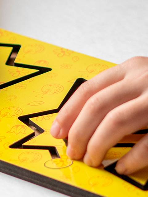 Un niño está jugando con un rompecabezas de formas de colores en una mesa.