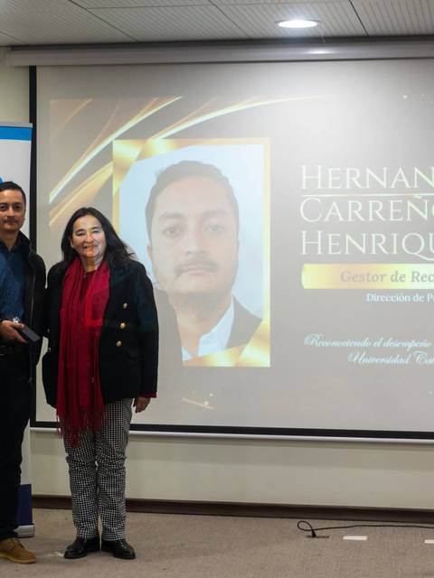 Una entrega de reconocimiento a Hernán P. Carreno Henríquez en un evento en la universidad.
