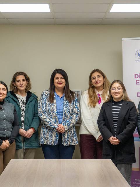 Un grupo de mujeres posando juntas en un ambiente de oficina.