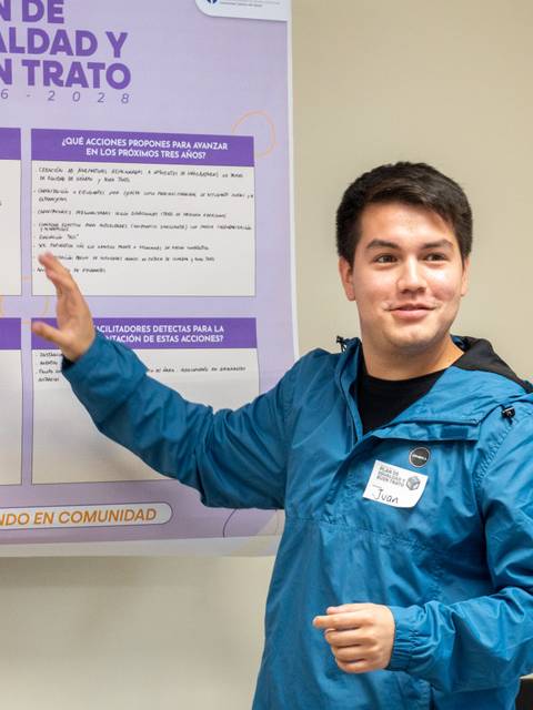 Un joven está presentando ideas en un taller sobre el plan de igualdad y buen trato.