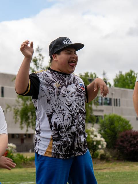 Un grupo de jóvenes se divierte bailando al aire libre en un día nublado.