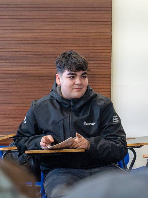 Un cabro se ve atento en una sala de clases.