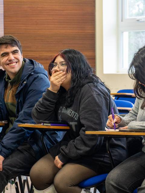Un grupo de estudiantes en un aula, disfrutando y compartiendo risas.