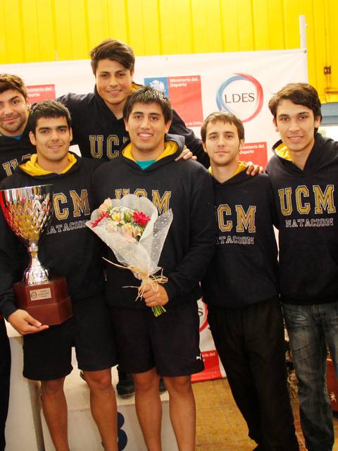 Equipo de deportistas posando con un trofeo y una celebración tras ganar un campeonato.