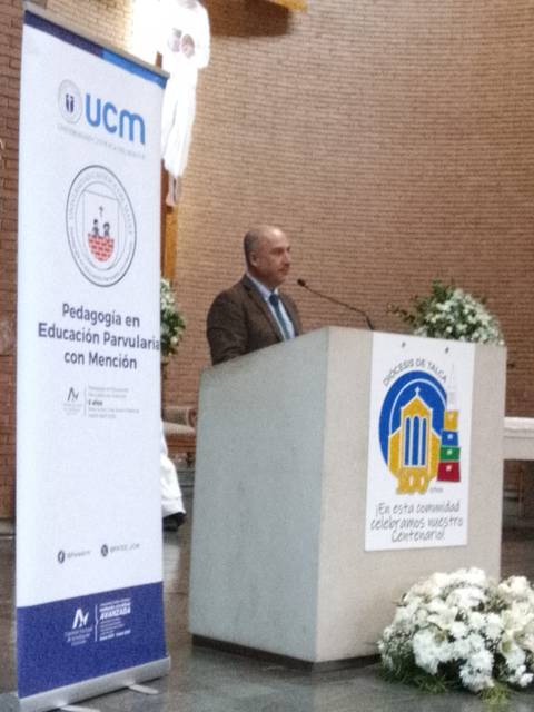 Un hombre habla desde un podio en un evento educativo.