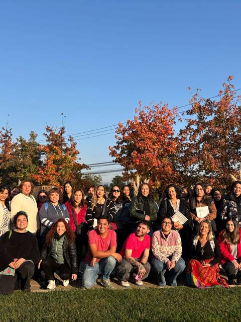 Un grupo grande de personas posando juntas al aire libre en un día soleado.