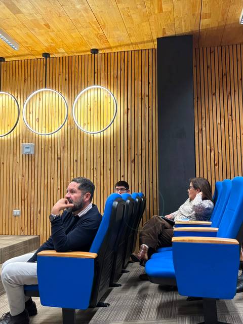 Una charla en un auditorio con varios asistentes prestando atención.