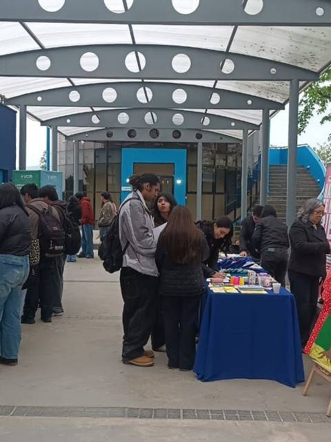 En la imagen se observa a un grupo de personas participando en una feria educativa al aire libre.
