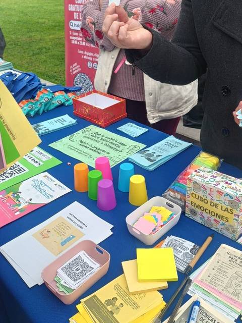 Una mesa llena de materiales educativos y coloridos para un taller en el parque.