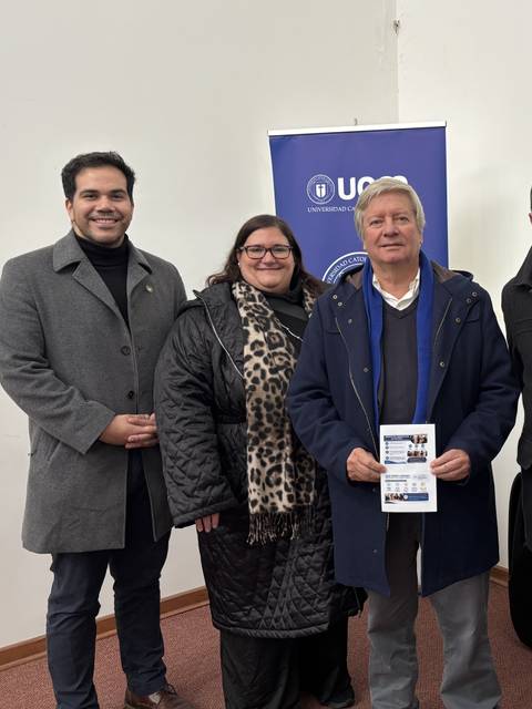 Un grupo de personas posando en un evento con un cartel en mano.