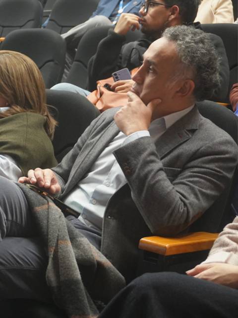 Un grupo de personas atentas en un evento en un auditorio.
