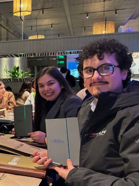 Cuatro amigos disfrutando de una cena en un restaurante mientras revisan el menú.