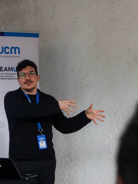 Un ponente mostrando una presentación en un evento en la UCM.