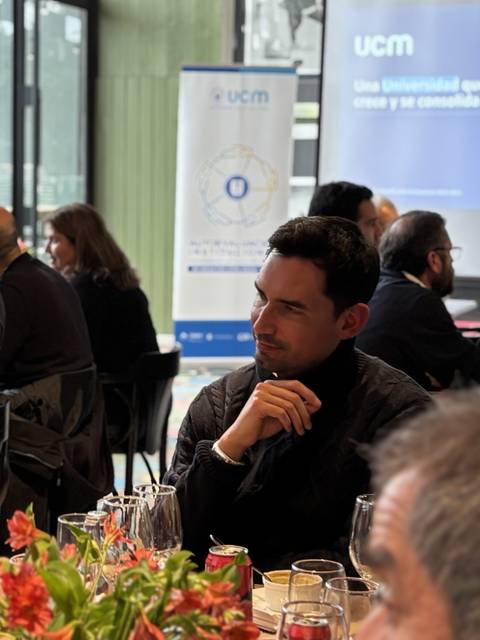 Un par de personas conversando en un ambiente de reunión empresarial.