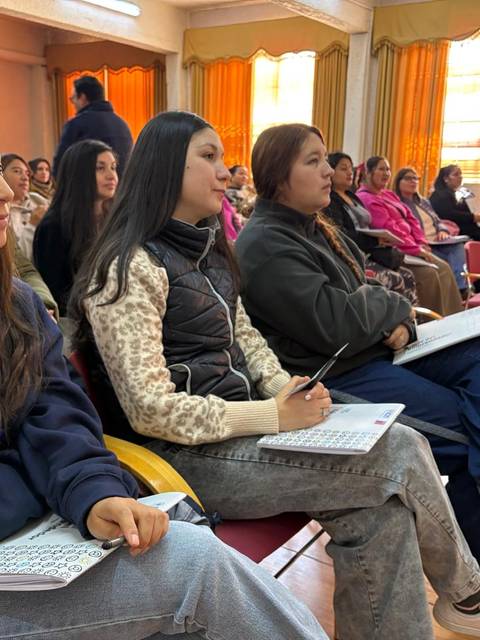 Grupo de personas participando en una charla o taller en un salón.