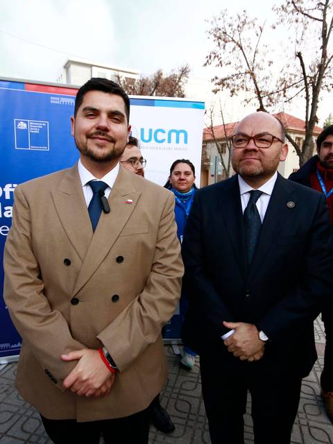 Dos hombres posando en un evento al aire libre en Chile.