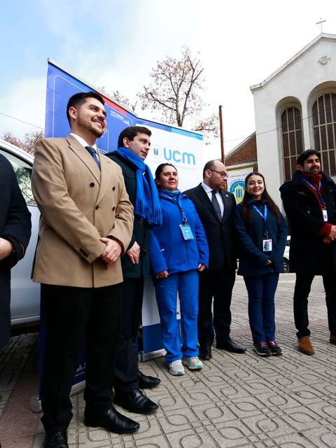 Grupo de personas posando frente a una iglesia en un evento comunitario.
