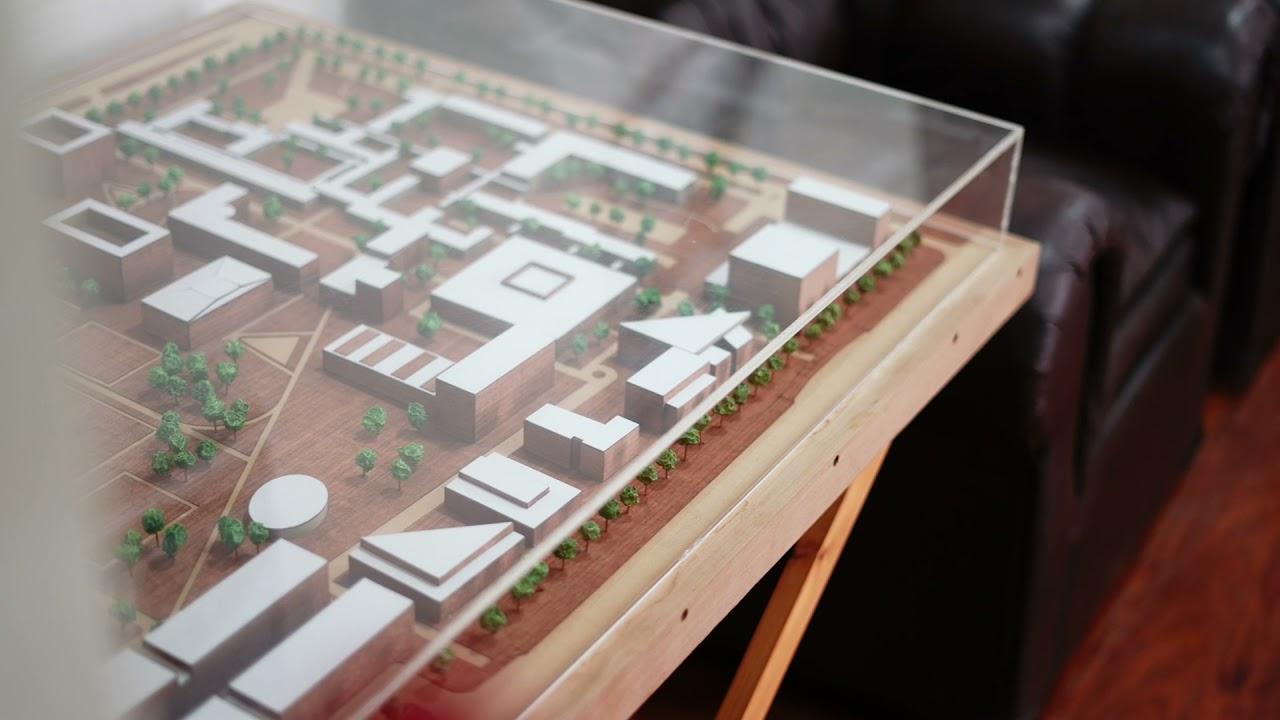 Una maqueta arquitectónica de un diseño urbano, expuesta sobre una mesa de madera.