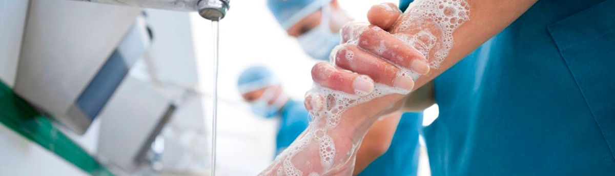 Personas en un entorno médico lavándose las manos con jabón.