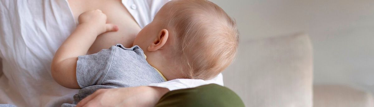 Una madre amamanta a su bebé en un ambiente acogedor.
