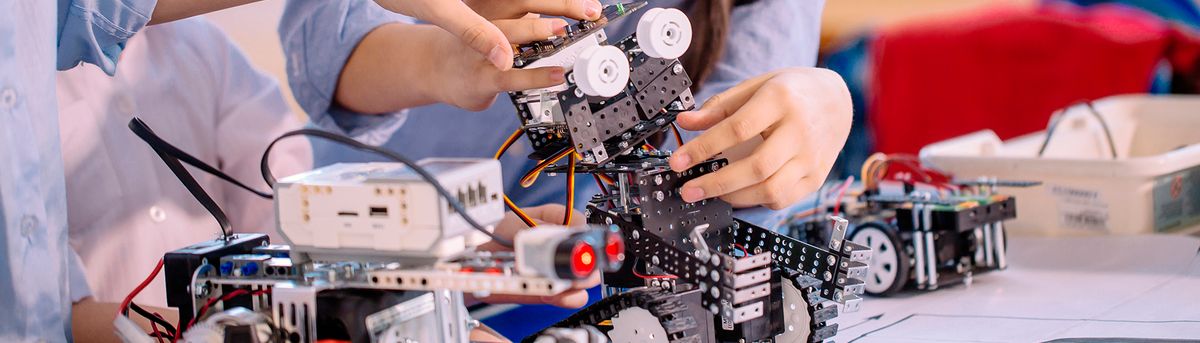 Un grupo de personas trabaja en la construcción de un robot utilizando piezas y componentes electrónicos.