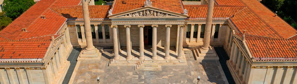 Imagen aérea de un edificio con columnas y tejados de tejas rojas, característico de la arquitectura clásica.