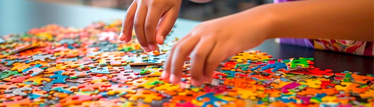 Un niño está armando un rompecabezas colorido sobre una mesa.