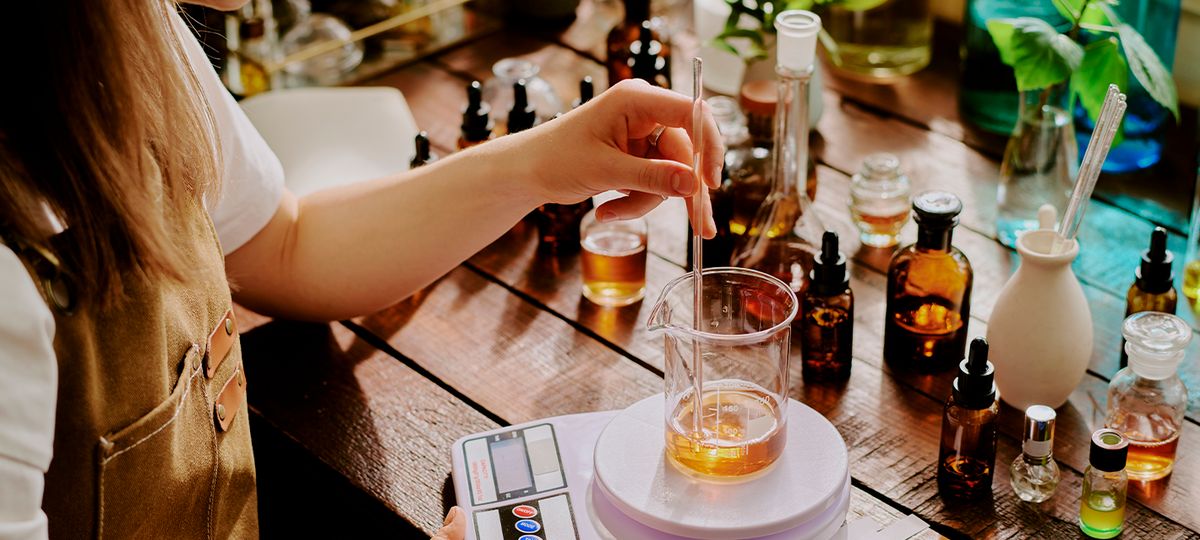 Una persona está preparando una mezcla en un laboratorio de productos naturales.