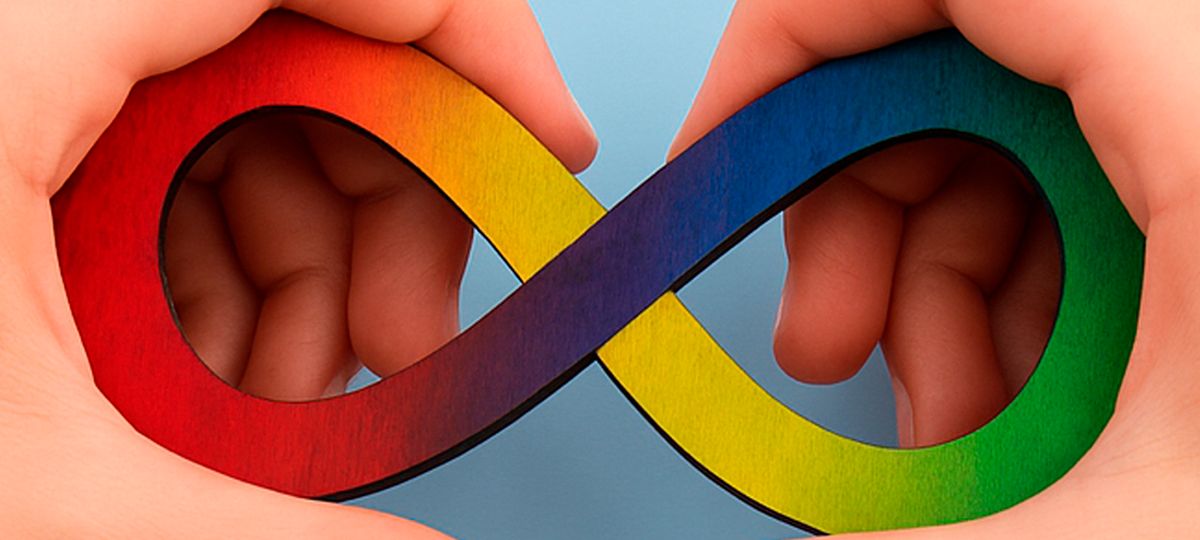 Un símbolo de infinito colorido sostenido por dos manos, representando la diversidad y la inclusión.