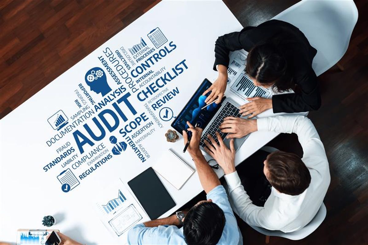 Un grupo de profesionales trabajando en una reunión sobre auditoría en una mesa.