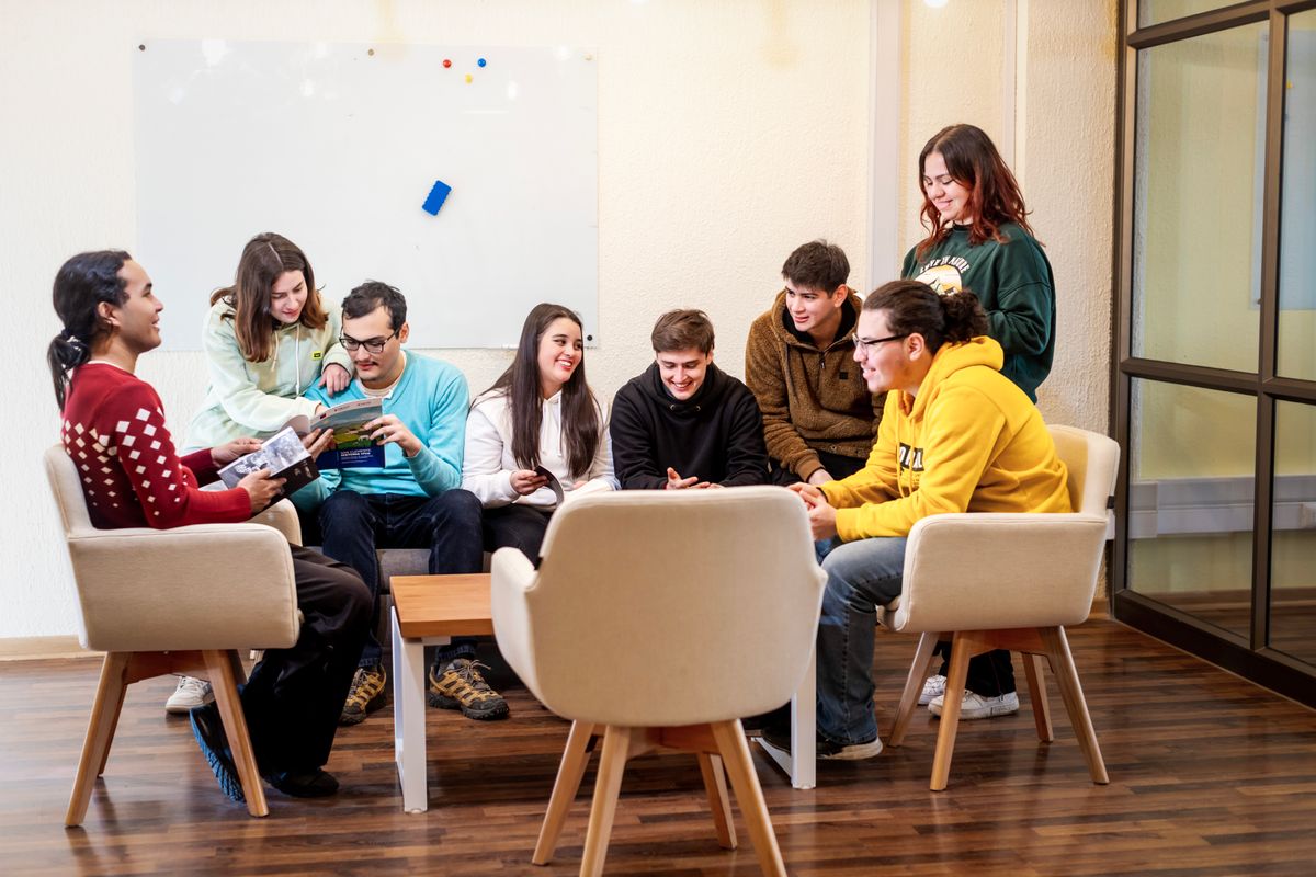 Un grupo de jóvenes se reúne en un ambiente acogedor para compartir y disfrutar de su tiempo juntos.
