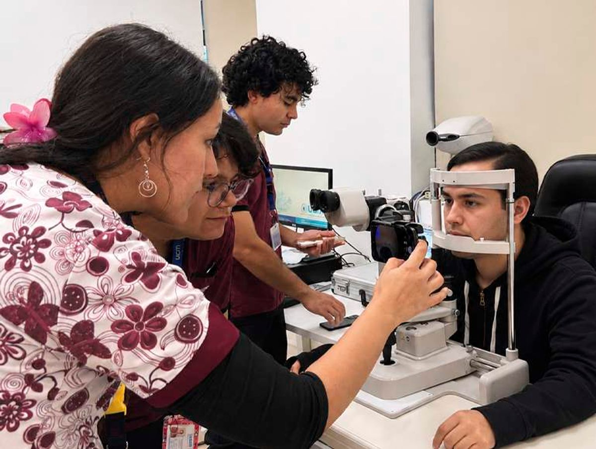 Un grupo de profesionales de la salud está realizando un examen ocular a un paciente en un centro médico.