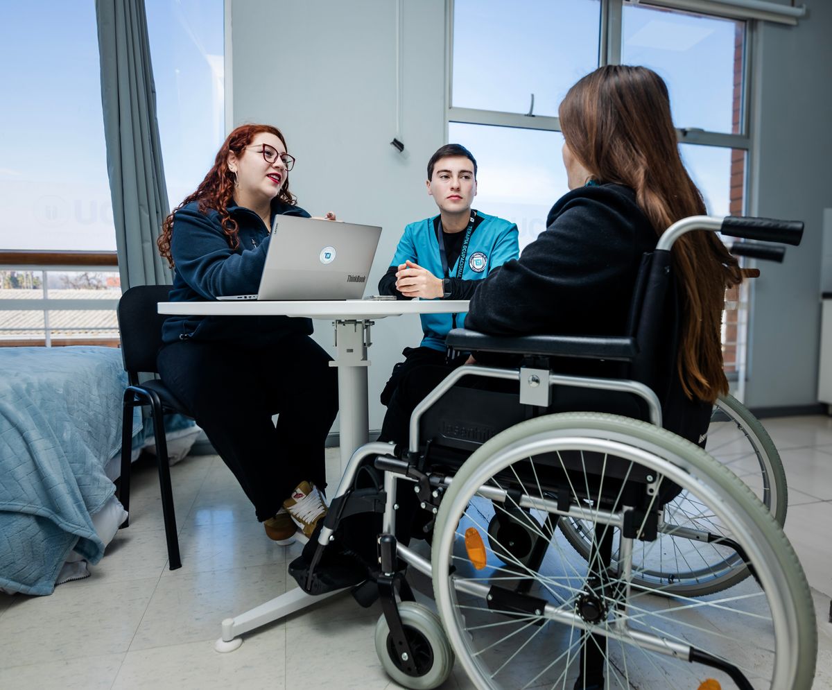 Un grupo de jóvenes conversando en un ambiente acogedor, donde una de ellas está en silla de ruedas.