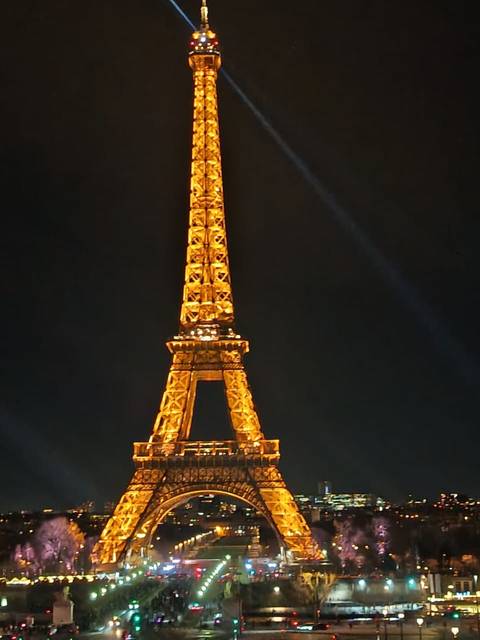 La Torre Eiffel brilla con luces doradas en una noche parisina.
