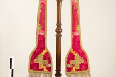 El objeto en la imagen es un soporte decorado con rojo y dorado, utilizado en ceremonias religiosas.