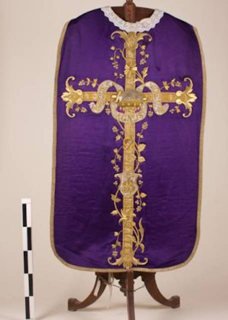 La imagen muestra una vestimenta religiosa de color púrpura decorada con un diseño dorado y floral.