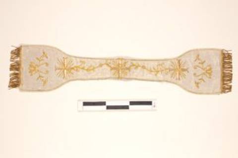 Una banda decorativa con bordado dorado y flecos en los extremos.