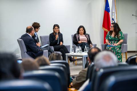Un panel de discusión en un evento en Chile con cuatro participantes hablando sobre temas relevantes.