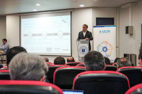 Un expositor presenta en un auditorio con mucha atención de los asistentes.