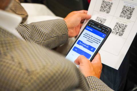 Una persona usando su celular para escanear un código QR en un evento.