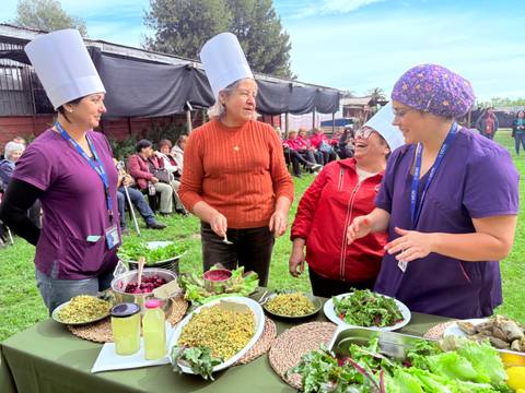 Un grupo de mujeres chilenas se reúne para compartir y preparar ensaladas frescas en una actividad al aire libre.