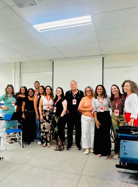 Grupo de profesionales reunidos en un ambiente escolar, todos sonriendo y posando para la foto.