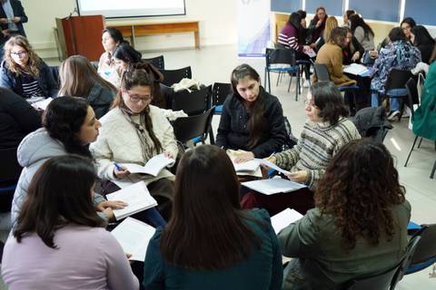 Un grupo de mujeres se reúne en un taller para intercambiar ideas y experiencias.