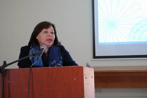 Una mujer habla frente a un micrófono en un evento oficial.