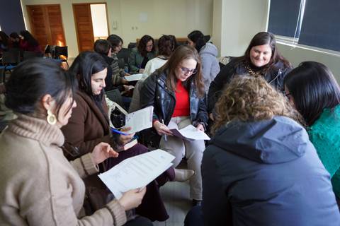 Un grupo de mujeres en una dinámica de trabajo colaborativo, revisando documentos y compartiendo ideas.