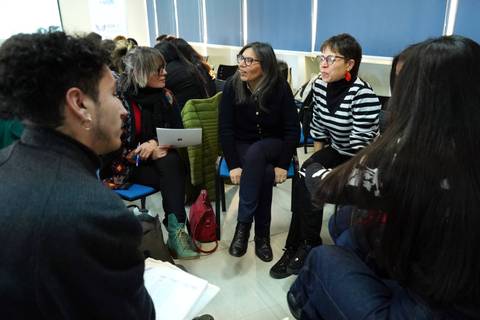Un grupo de personas conversando en un taller en un ambiente acogedor.