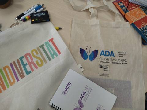 Una imagen que muestra dos mochilas de tela con motivos de diversidad y un cuaderno del Observatorio ADA.