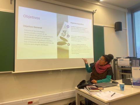 Una mujer está presentando objetivos en una sala de clases.